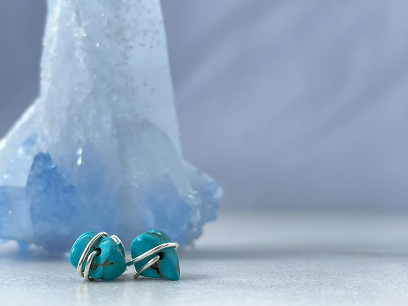 silver turquoise stud earrings designed by Summer Gems in Barbados . Earring next to a blue agate geode