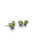 A pair of silver stud earrings featuring small, faceted green gemstones wrapped in delicate silver wire, shown on a clean white background.