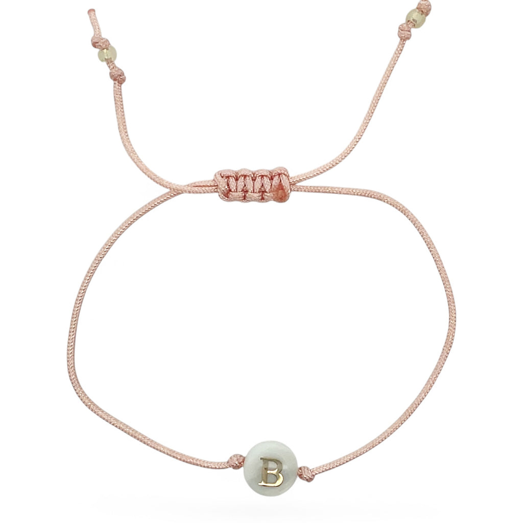 Pink bracelet with a green bead featuring the letter 'B' on a white background