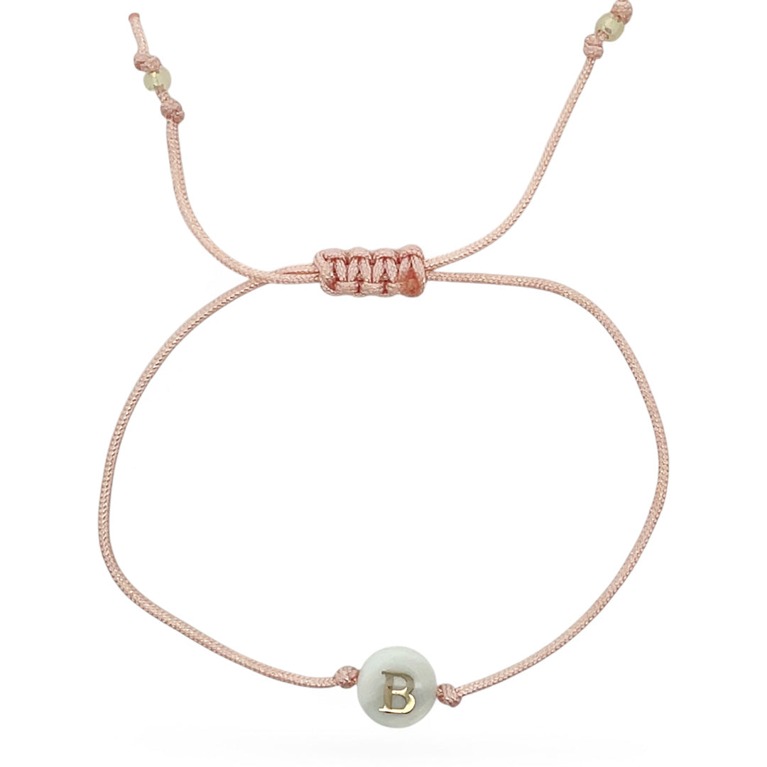 Pink bracelet with a green bead featuring the letter 'B' on a white background
