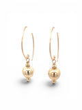 A pair of gold drop hoop earrings with a polished spherical bead dangling from a thin curved hook, shown on a clean white background.