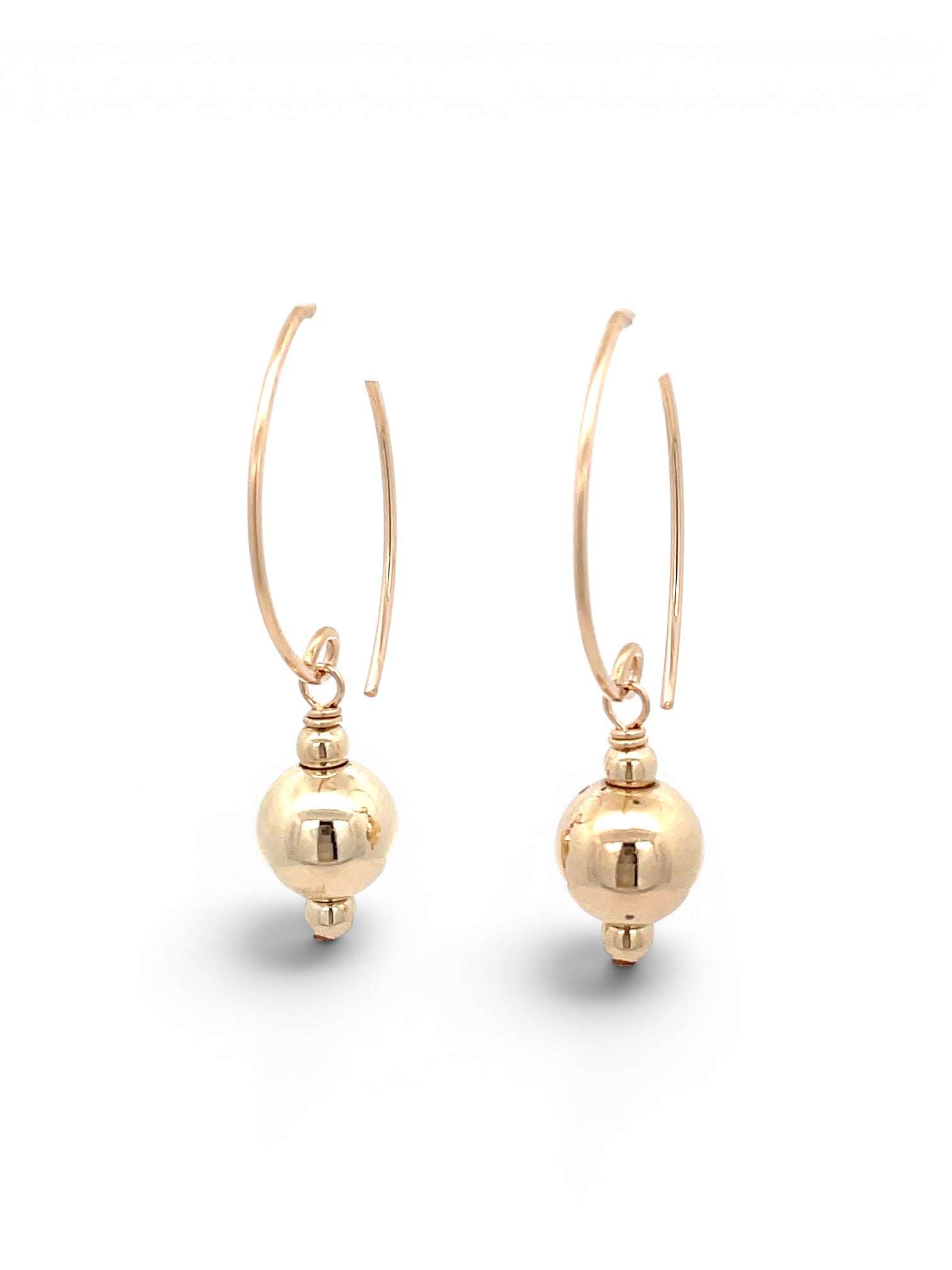 A pair of gold drop hoop earrings with a polished spherical bead dangling from a thin curved hook, shown on a clean white background.