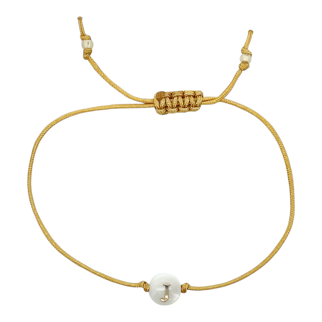 Gold bracelet with white beads on a white background
