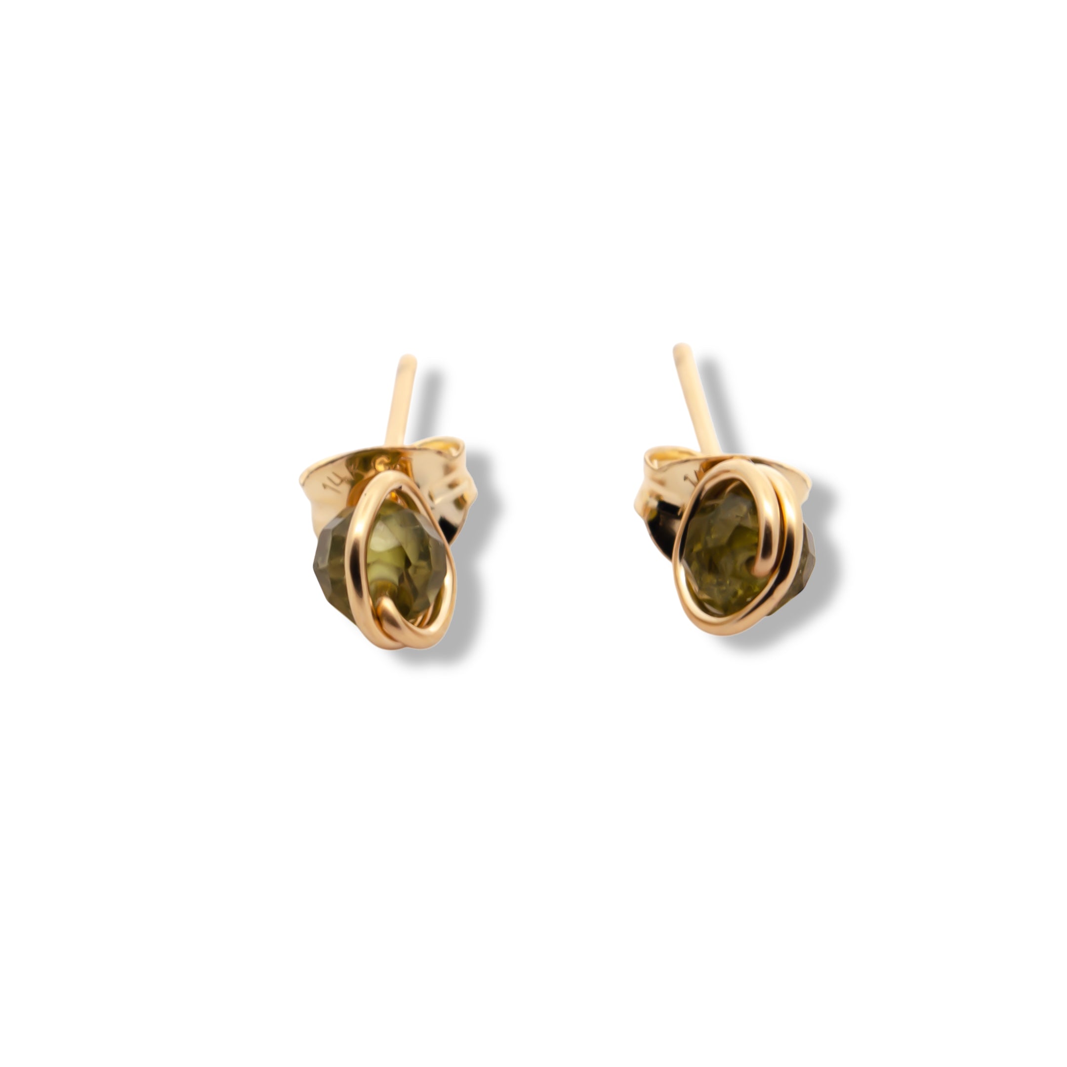 Gold earrings with green gemstones on a white background