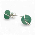 Green earrings with silver loops on a white background