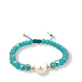 Turquoise beaded bracelet with a gold accent and pearl on a white background