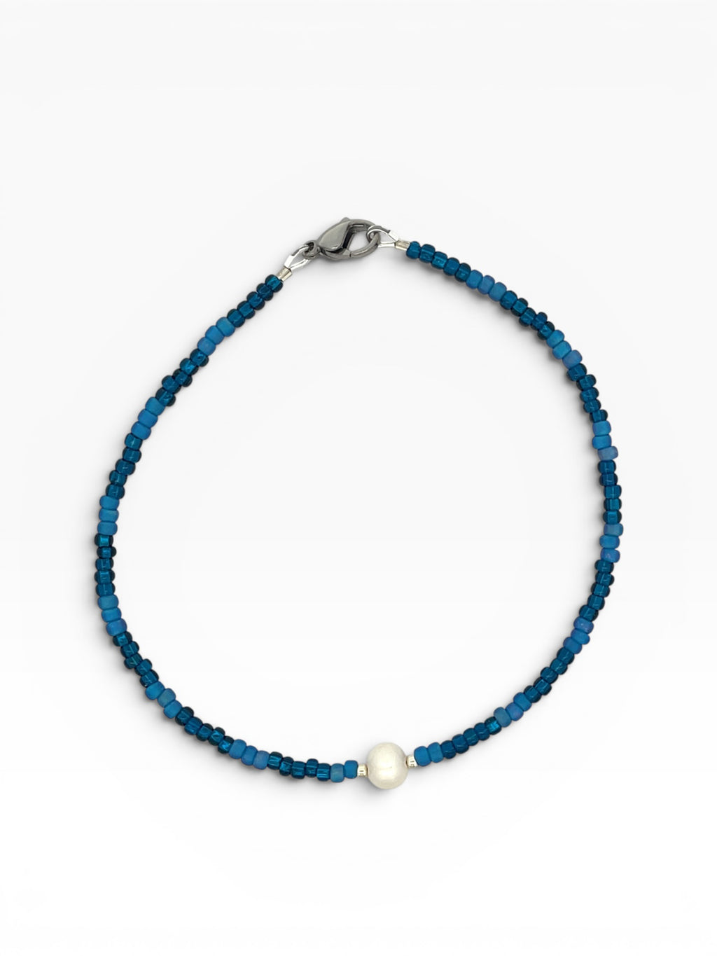 Blue beaded anklet with a white pearl on a white background
