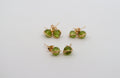 Three pairs of gold stud earrings with round green gemstones, shown on a plain light gray background.