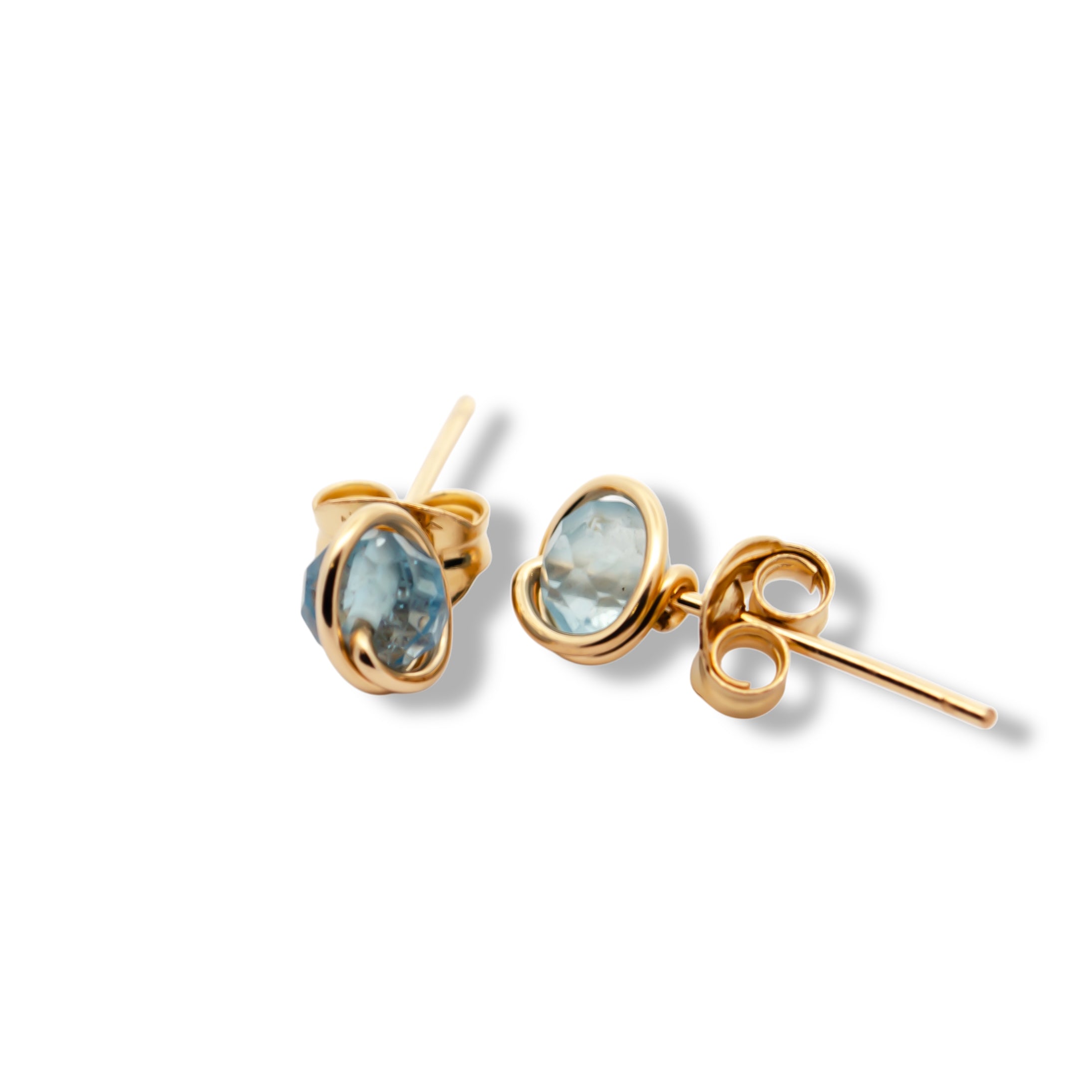 Gold earrings with blue gemstones on a white background