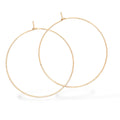 Close-up of large hand-forged gold hoop earrings in yellow gold-filled, displayed on a white backgroun