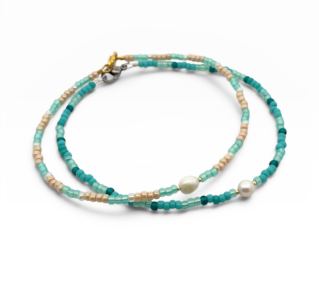 Two layered beaded Anklets with green, beige, and white beads on a white background