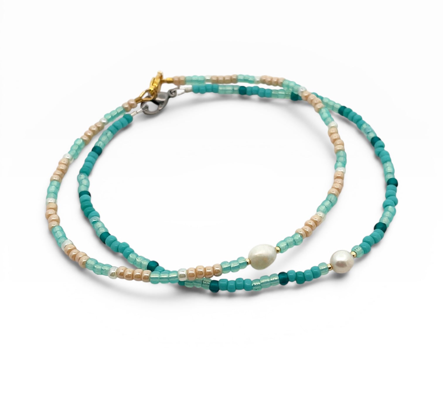 Two layered beaded Anklets with green, beige, and white beads on a white background