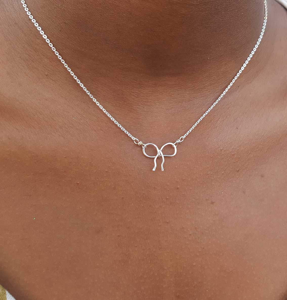 silver bow necklace on model 